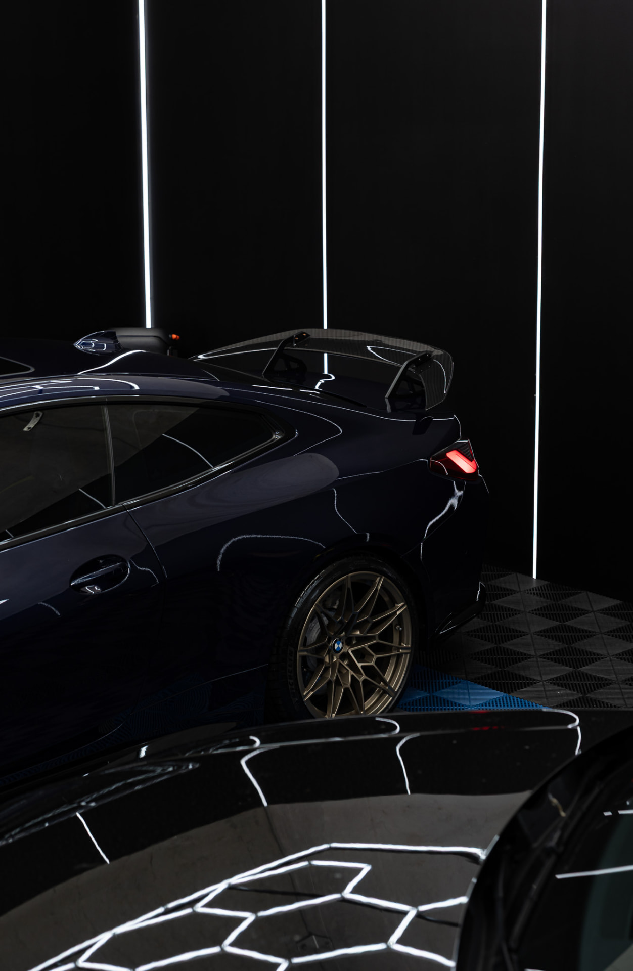 Tinted BMW glass reflecting the workshop inspection lights